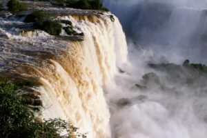 Breathtaking view of Iguazu Falls cascading with mist and lush greenery.