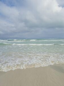 Peaceful ocean waves gently hitting Varadero Beach, Cuba, under a cloudy sky.