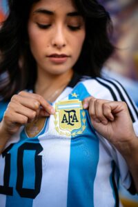 Close-up of a woman showing Argentina football jersey with the AFA emblem.